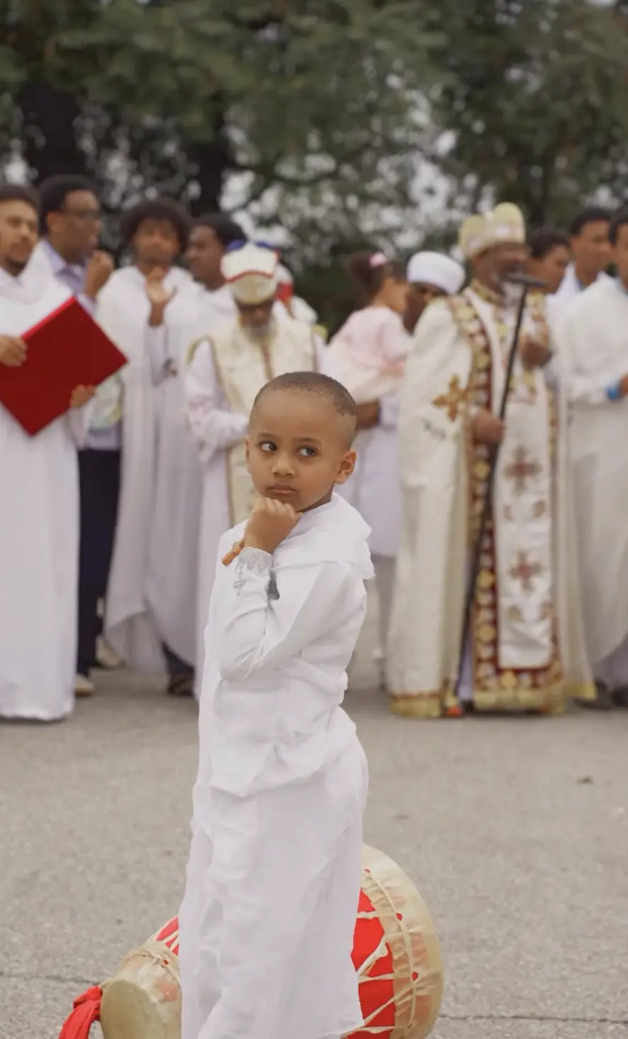 Young child in white at an outdoor church procession