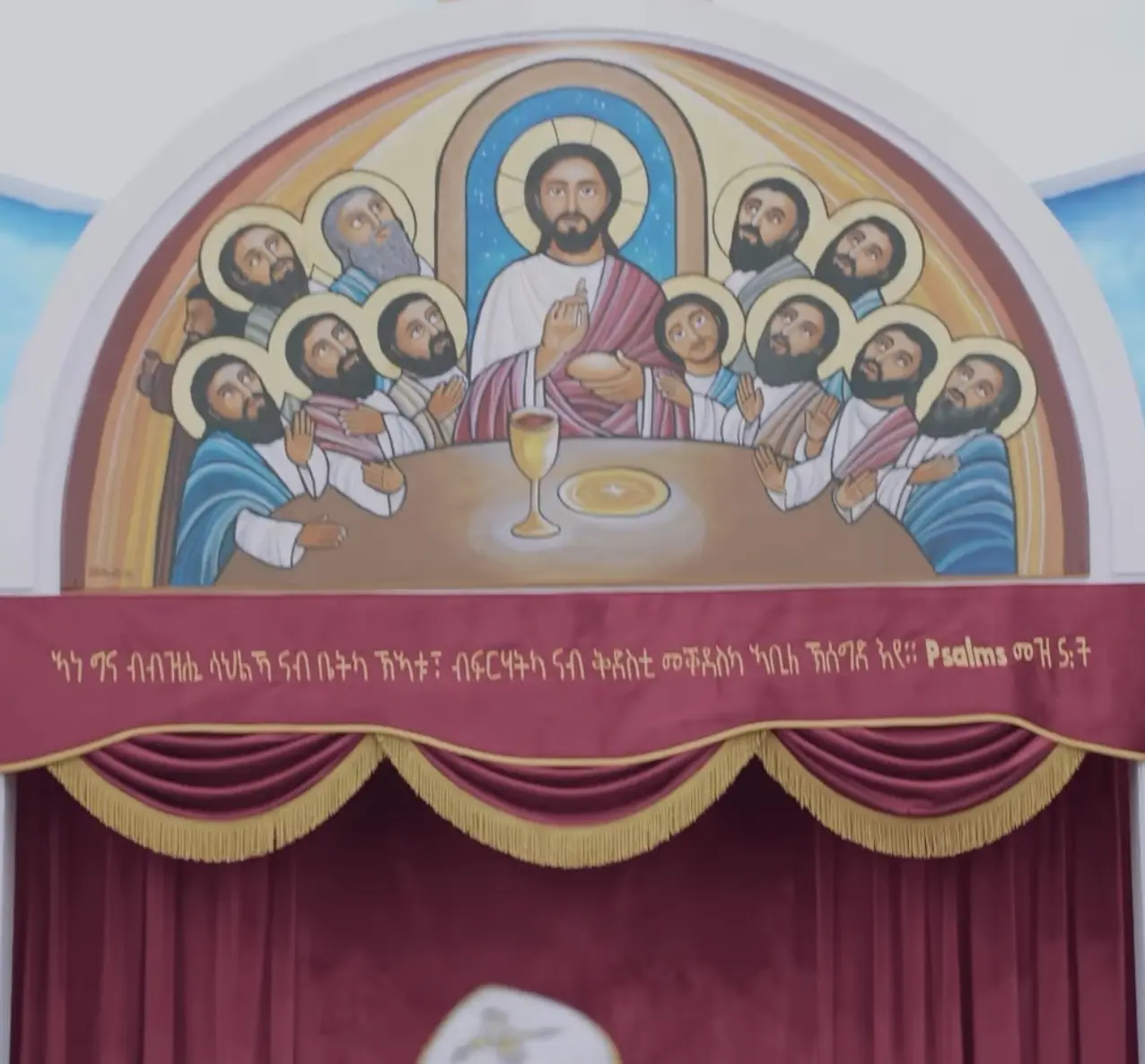 Last Supper mural with Ge'ez scripture above maroon curtains inside Medhane Alem Church