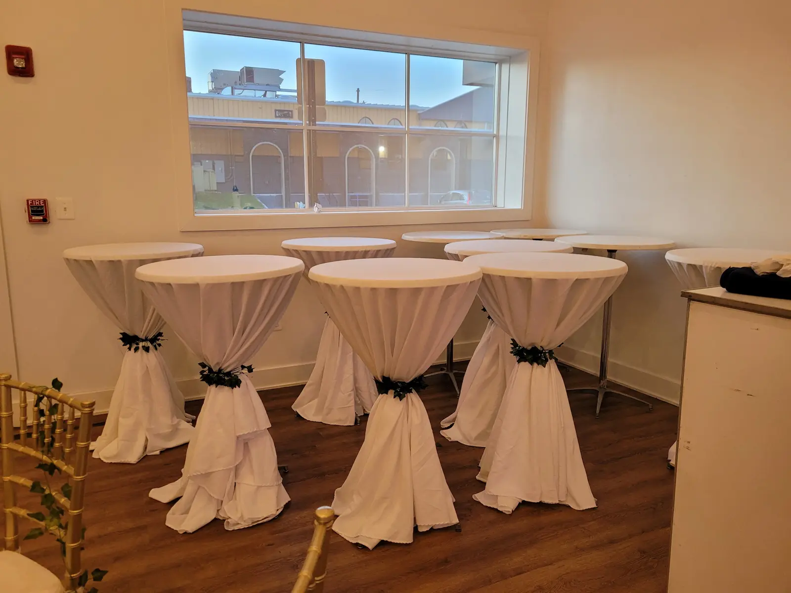 Cocktail area with draped high-top tables set for a reception