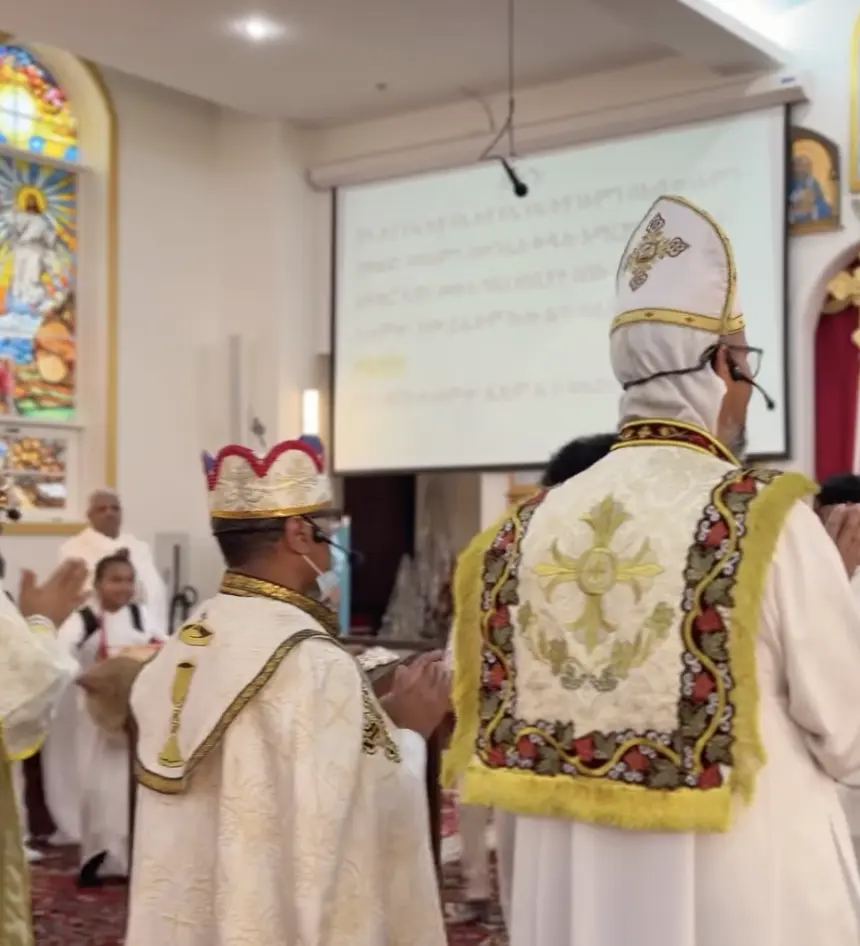 Congregation seated in white garments during a service at Medhane Alem Church